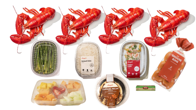 Lobster dinner catering spread with four whole lobsters, asparagus, sauces, and sides, perfect for celebrations and events.